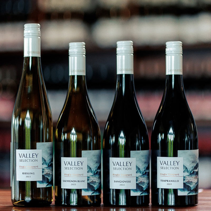Four bottles of Gapsted Estate Valley Selection single vineyard wines, including Riesling, Sauvignon Blanc, Sangiovese and Tempranillo, displayed on a cellar door bench